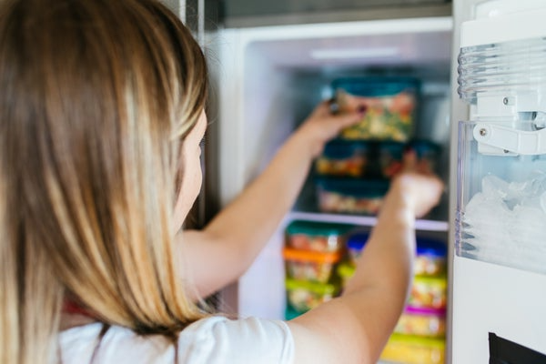 Woman putting food in freezer
